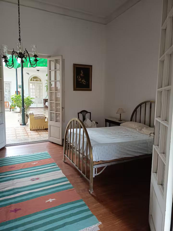 Habitación de CasaGrande con camas individuales, piso de madera y puertas vidriadas al patio