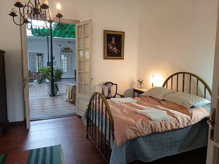 Habitación de CasaGrande con cama matrimonial, luz cálida y vista al patio interior