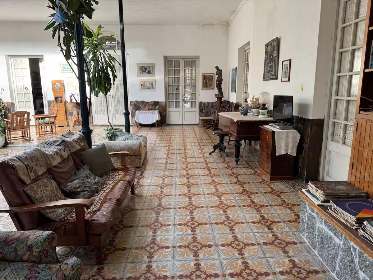 Salón interior de CasaGrande con muebles de época, piano y biblioteca