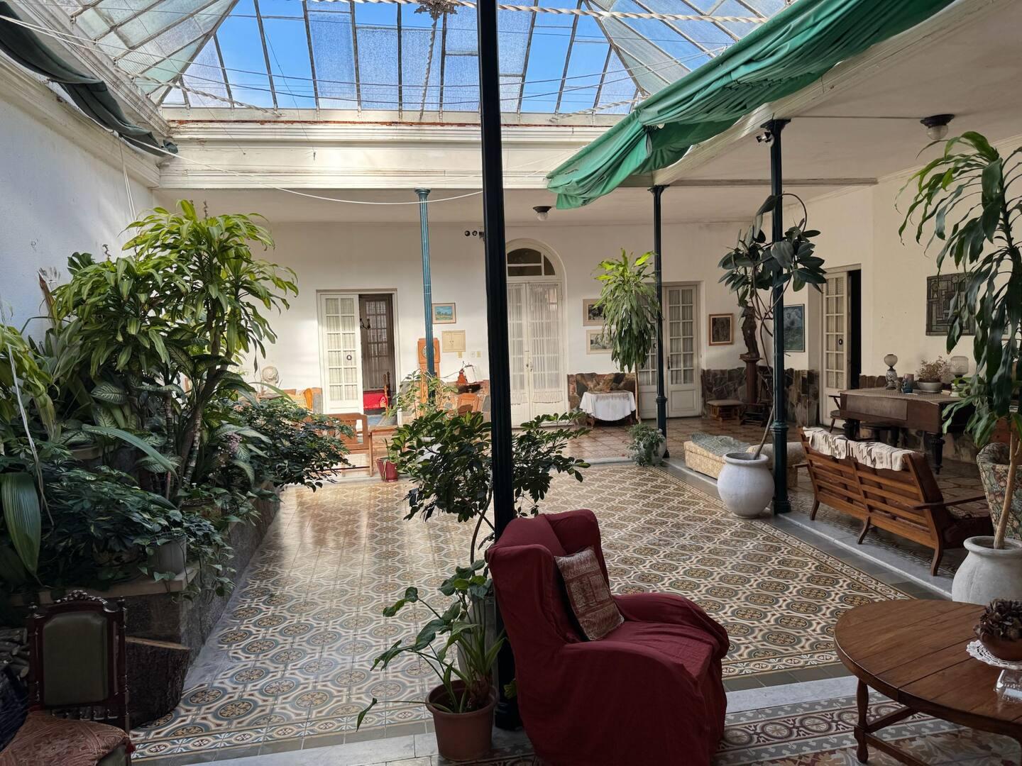 Patio interior de CasaGrande, con columnas de hierro, claraboya y muebles de época